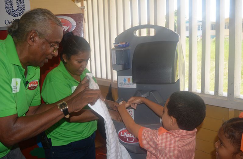 Michael Khan and Natasha Azeez teaching children how to wash their hands properly