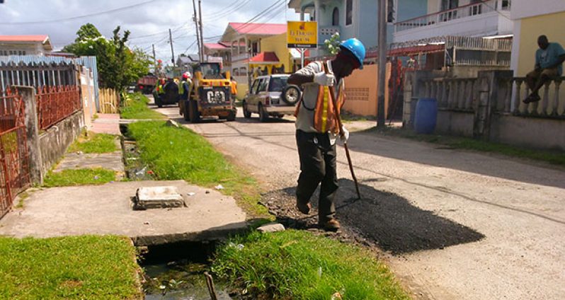 Workmen hard at it yesterday in the Middle Road La Penitence area (Photo by Ravin Singh)