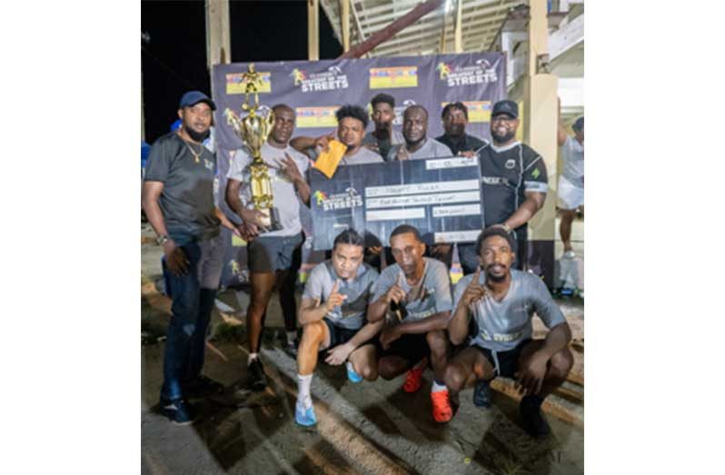 Banks DIH Brand representative Jeff Clement, Banks DIH Bartica Branch Manager Keron Savoury (right), and Bartica Branch Outdoor Supervisor Keanu Harry, (second right), with the Mighty Ruler players   after the trophy presentation