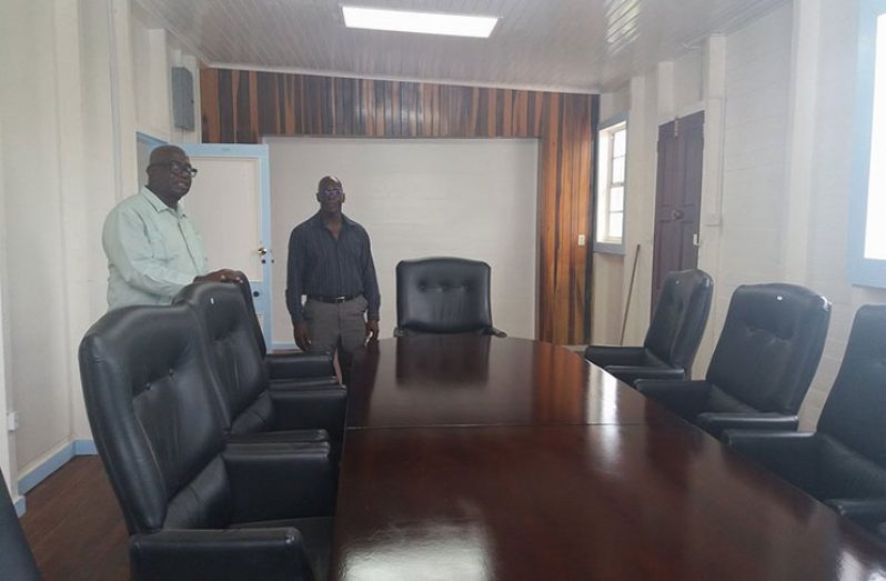 Chairman of the LGC Mortimer Mingo and his deputy Andrew Garnett standing in the boardroom of the Commission.