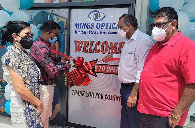 Rose Hall Mayor Dave Boodhu cuts the ceremonial ribbon for the official opening of the new, upgraded location of Mings Optical in the presence of Minister of Health, Dr. Frank Anthony (third left); Regional Chairman David Armogan (extreme right) and proprietrix, Dr. Michelle Ming (extreme left)