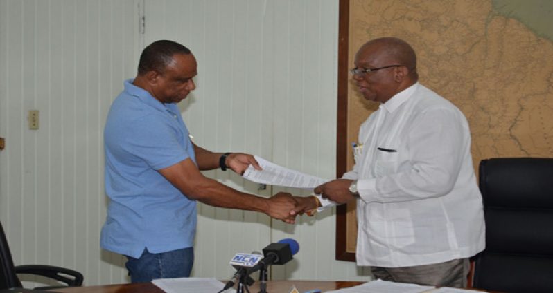 Finance Minister Winston Jordan presenting the signed agreement to GGDMA President, Terrence Adams