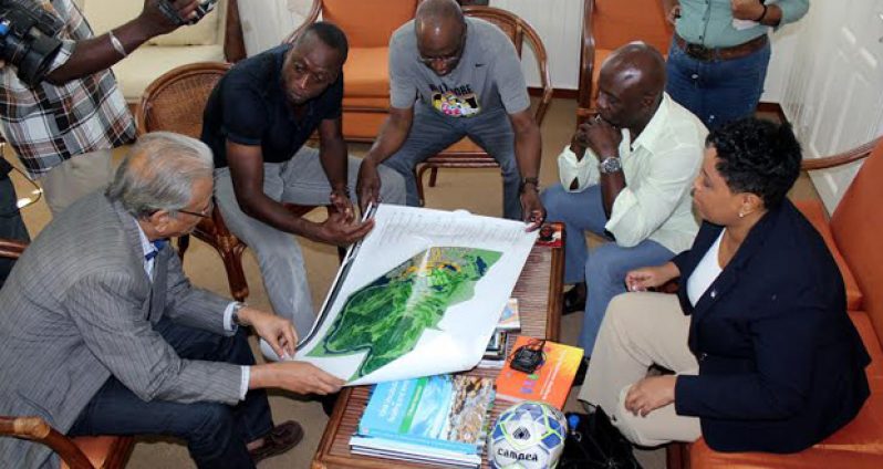 Minister of Education Dr Rupert Roopnarine (first from left) engaged by Alex Bunbury during the Guyanese/Canadian football player’s visit.
