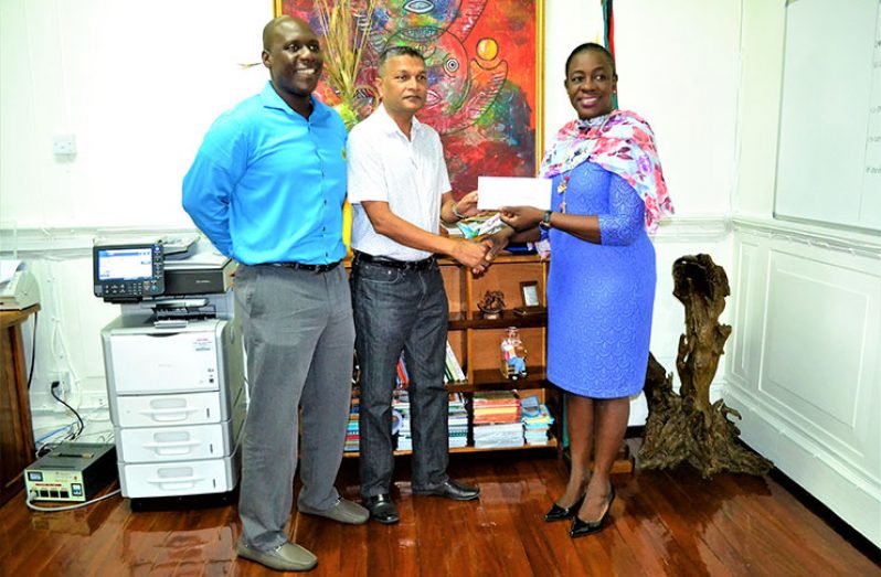 In photo, Minister Nicolette Henry presents the cheque to GCB secretary Anand Sanasie. Looking on is GCB’s Territorial Development Officer Colin Stuart.