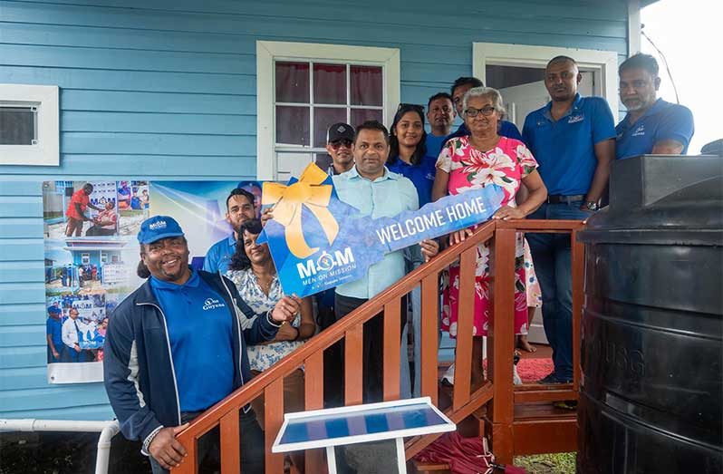 Minister within the Ministry of Public Works, Deodat Indar, representatives from Men on Mission handing over a home to Dhanraji Guradai