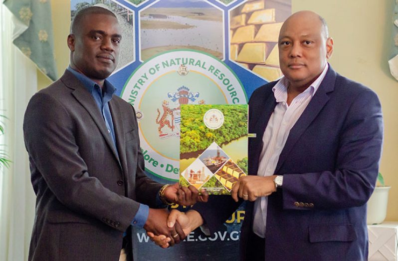 Natural Resources Minister Raphael Trotman (right) and CI-Guyana Senior Technical Director Curtis Bernard (left), shake hands as they hold a copy of the signed MoU (Delano Williams photo)