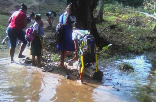 Mora-Camp-3 One of the 25 children from Mora Camp braving the murky waters to get to school