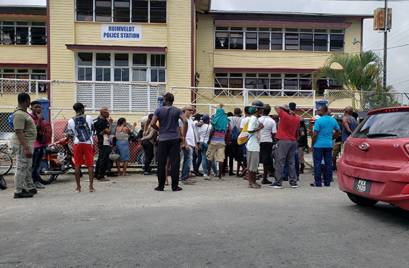 Persons outside the Ruimveldt Police Station awaiting an opportunity to purchase via the auction.