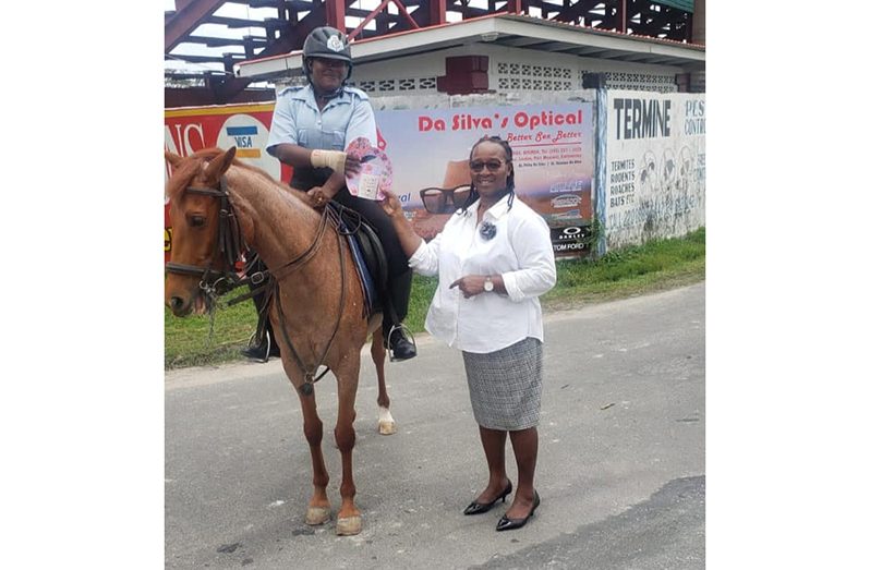 Woman Special Constable Drakes Pryce receives a token of appreciation from the Human Resource Officer of the National Park