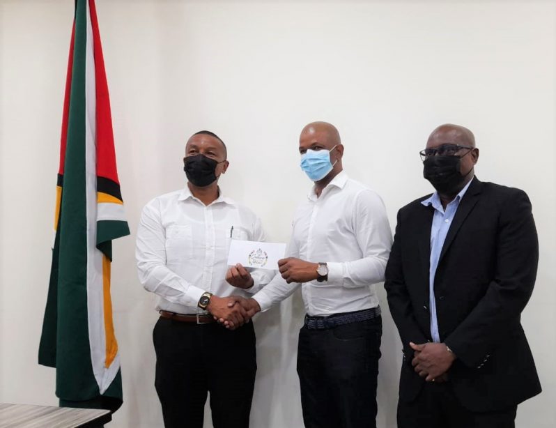 GTTA president Godfrey Munroe receives the cheque on Chelsea Edghill’s behalf from Chairman of the NSC, Kashif Muhammad, (first from left) and Director of Sport Steve Ninvalle (first from right).