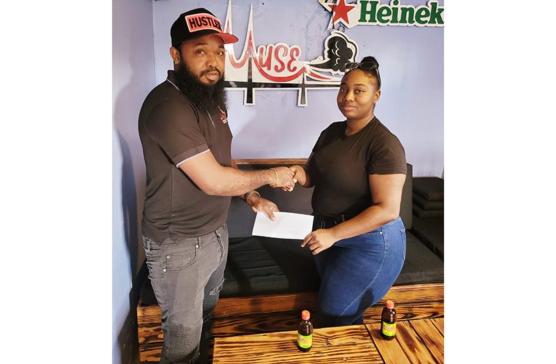 Supervisor at Muse Hookah Bar, Kevin Evans (left), hands over the sponsorship to Khashana Yhap at the popular Mandela Avenue outlet yesterday.