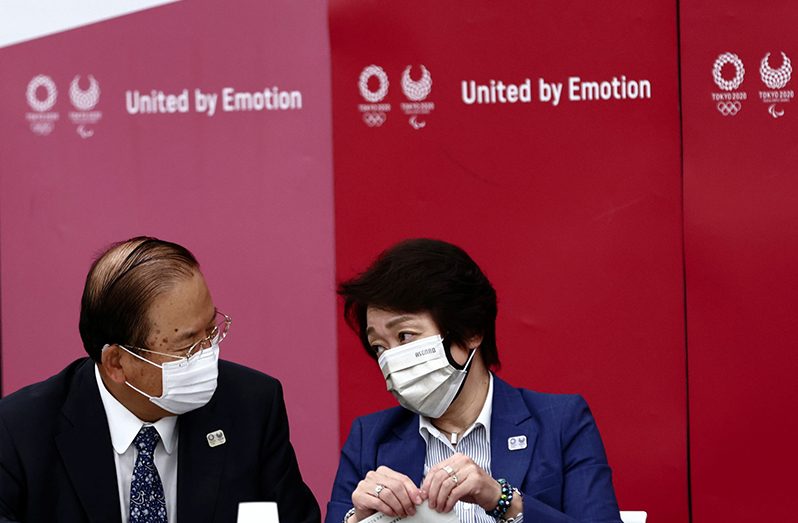 Tokyo 2020 Olympics organising committee president Seiko Hashimoto and Tokyo organising committee CEO Toshiro Muto chat before the start of the Tokyo 2020 Olympics executive board meeting in Tokyo, Japan June 8, 2021. (Behrouz Mehri/Pool via REUTERS)