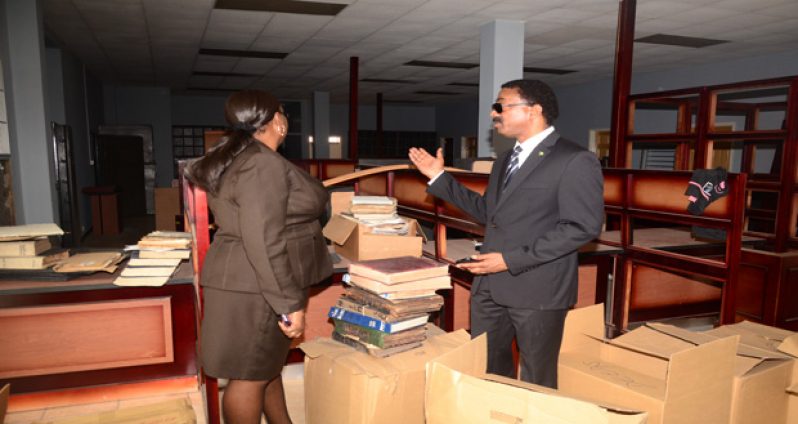 Attorney General and Minister of Legal Affairs Basil Williams in conversation with a member of staff amidst boxes and furniture