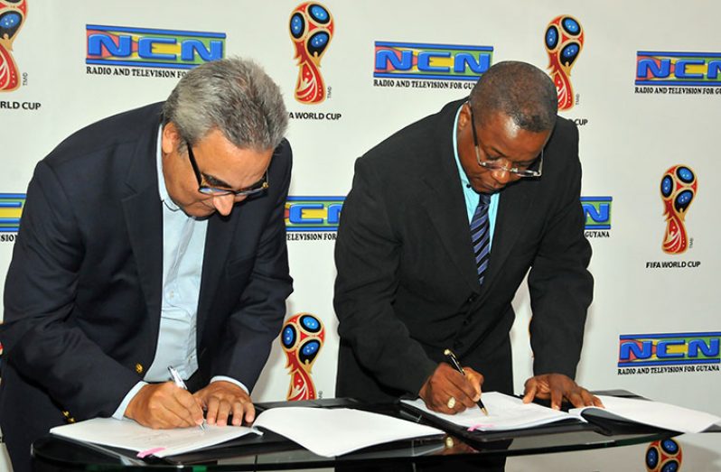 It’s a done deal! Bernard Pantin, DIRECTV’s Caribbean and Latin America Director (left) and NCN’s CEO Lennox Cornette, signing the agreement to make NCN the Official Broadcast Rights Holder for the 2018 FIFA World Cup. (Adrian Narine photo)