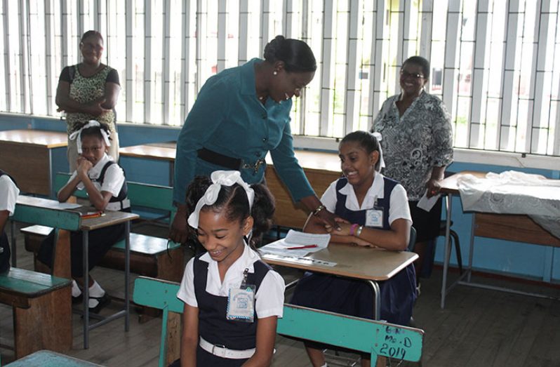 NGSA1: Minister of Education, Dr. Nicolette Henry shared a light moment with a young pupil of the Ketley Primary school moments before the 2019 NGSA got underway