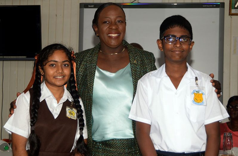 All smiles: Minister of Education  Dr Nicolette Henry (centre) shares a moment with this year's NGSA’s top performers, Venisha Lall (left) and Dave Chowtie.(Adrian Narine photo)