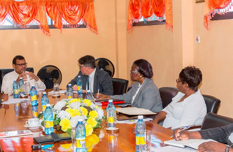 Chairman of NIS, Dr Surendra Persaud in conversation with International Labour Organisation (ILO) Senior Actuary, Mr. Georges Langis while other officials look on