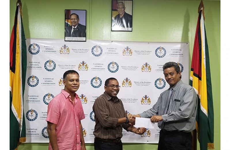 Seon Erskine, NSC's Technical Development Officer (second from left), makes the presentation to Anand Raghunauth.
