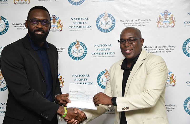 Director of Sport Christopher Jones (L), presents the Government of Guyana’s $2.5M cheque to GBA president Steve Ninvalle, towards sending five boxers and officials to the Olympic Qualifiers in Argentina. (Adrian Narine photo)
