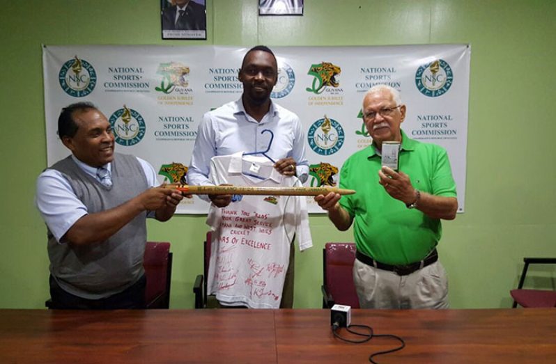 (L-R) Ivan Persaud, Christopher Jones and ‘Reds’ Perreira display the pieces of memorabilia donated.
