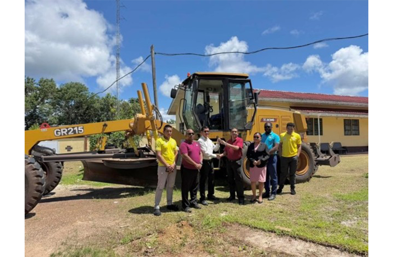 Regional Executive Officer (REO) Marti D’Souza receives the key for a motor grader