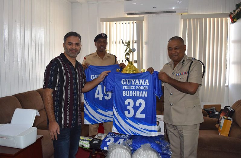 Deputy Commissioner 'Operations,' Ravindradat Budhram (at right) receives the donations from NYPD Cricket Team member Sheryar Hussain at his Eve Leary Office