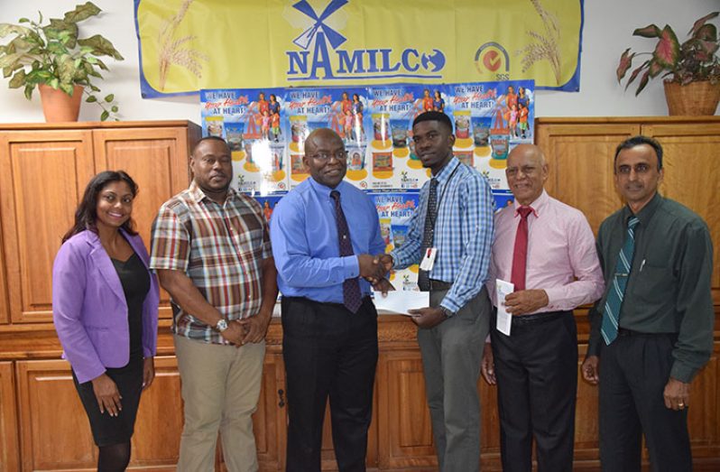 NAMILCO Finance Controller Fitzroy McLeod (3rd left) hands over the sponsorship cheque to Petra Organisation representative Mark Alleyne in the presence of Company officials and Petra’s Troy Mendonca (2nd left).