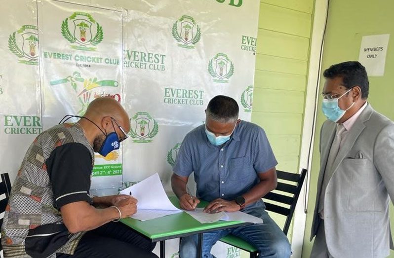 GTT’s Orson Ferguson (left) and Colonel Bhageshwar Murli sign the contract. Looking on is club president Manzoor Nadir.