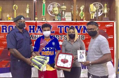 RHTYSC Assistant Secretary/CEO Simon Naidu hands over items to Mayor of Rose Hall Town, Dave Budhu.