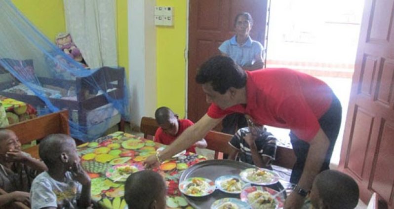 Minister of Legal Affairs and Attorney General Anil Nandlall distributing lunch to the children