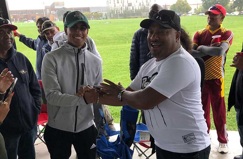 Matthew Nandu (left) receives monetary support from ardent supporter Eon Gunraj.