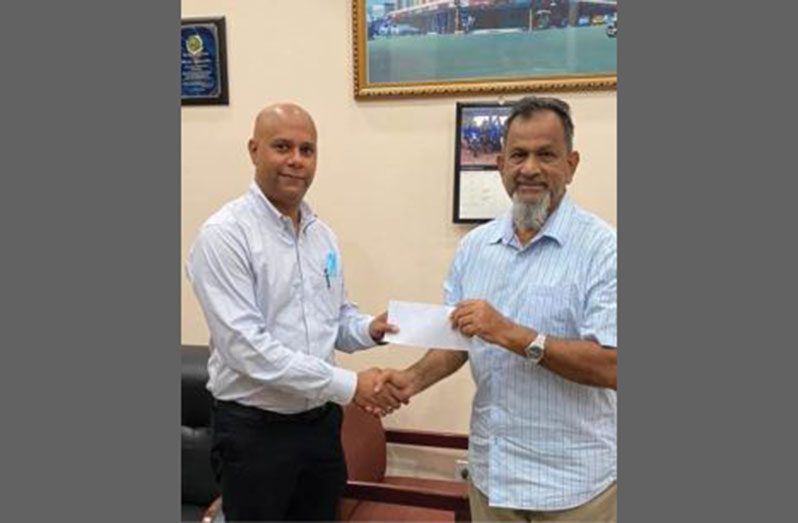 Proprietor Nazar ‘Shell’ Mohamed (right) makes the donation to GCC president Timothy Tucker, at Mohamed’s Enterprise