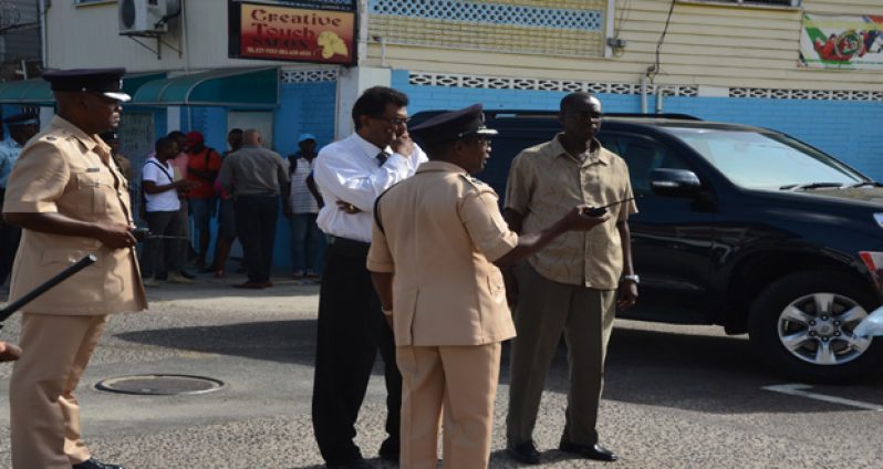 Minister of Public Security, Khemraj Ramjattan, being briefed by Police Divisional Commander Clifton Hicken before attending a meeting with the prisoners on Friday