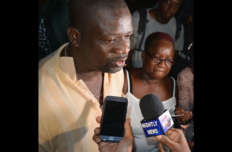 Neville Leslie and his sister talking to reporters at the crime scene