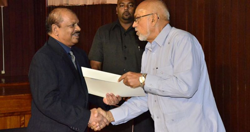 New Bank of Guyana Governor, Dr. Gobind Nauth Ganga receiving his certificate of appointment from President Donald Ramotar (Photo courtesy of Sandra Prince)