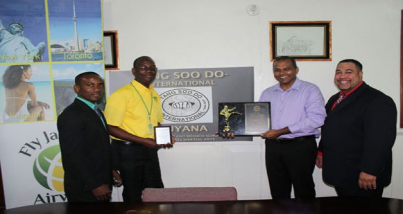 (L – R) Roland Eudoxie, Fly Jamaica Senior Marketing Officer Wesley Tucker, Minister of Sport Dr Frank Anthony and Master Jose Torres.