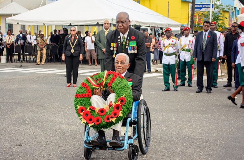 A veteran being wheeled to the Cenotaph, Avenue of the Republic, Georgetown, to lay his wreath in remembrance of the heroes who died in World Wars 1 and 11 (Samuel Maughn photo)