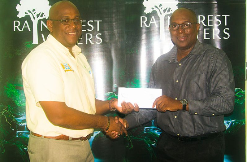 President of the Guyana Boxing Association (GBA) Steve Ninvalle receives the sponsorship cheque from Clive Pellew, Brand Manager (Water).