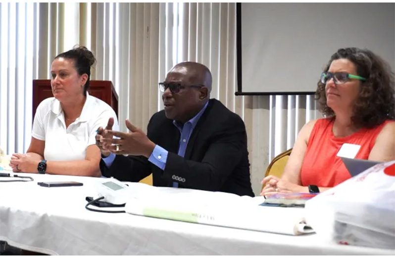 Director of Sport, Steve Ninvalle, flanked by Sarah Newton (left) and Tamara Wood (right) of the Canadian Lifesaving Society, makes a point to the participants of the programme.