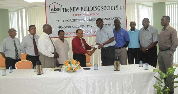 With executive members of both NBS and GCA looking on appreciatively, Chief Executive Officer Amad Khan (5th from left) presents the cheque to president of the GCA, Roger Harper. Also in picture is Chairman of NBS Floyd McDonald (3rddfrom left).