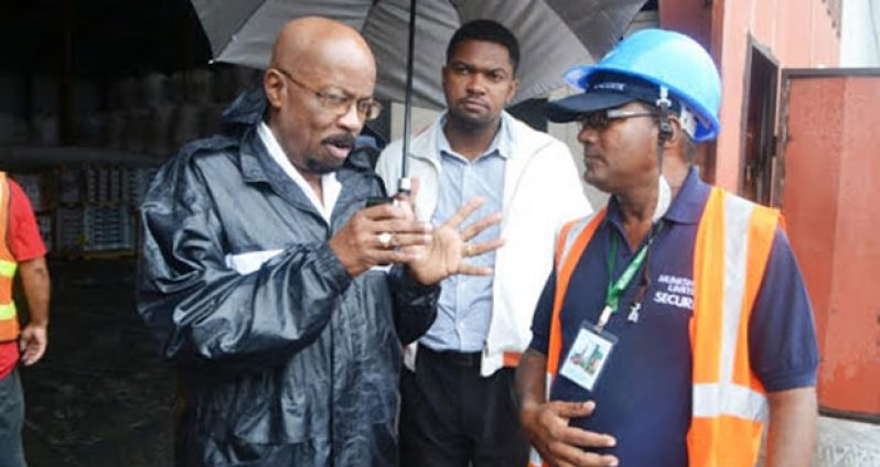 Minister Norman Whittaker engaging a staff at the  Muneshwar’s pump during a visit around the flood-hit City yesterday.