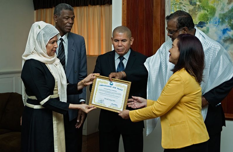 Minister of Social Cohesion, Dr. George Norton, receives the Ambassador of Peace Award from representatives of the UPF (Samuel Maughn photo)