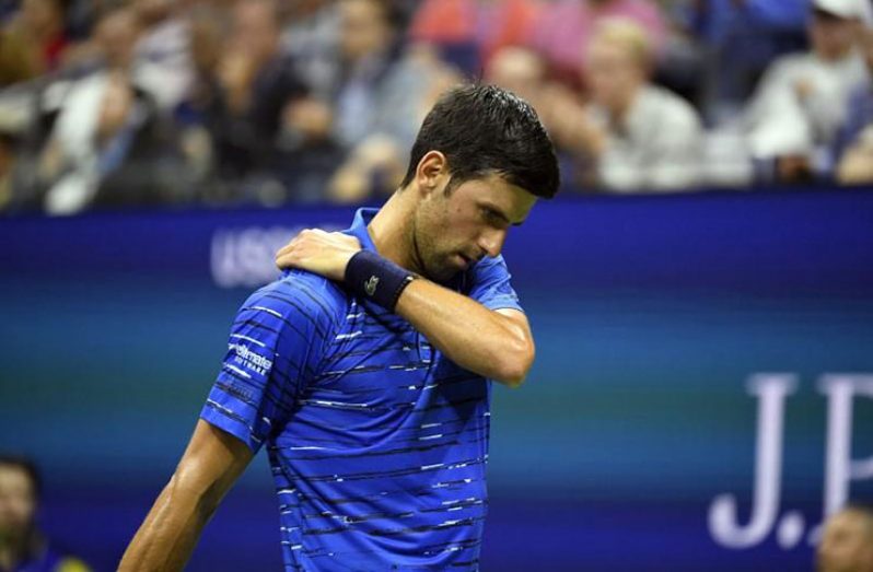 Flushing, NY, USA; Novak Djokovic of Serbia rubs his shoulder during a match against Stan Wawrinka of Switzerland in the fourth round on day seven of the 2019 US Open tennis tournament at USTA Billie Jean King National Tennis Center. Mandatory Credit: Danielle Parhizkaran-USA TODAY Sports