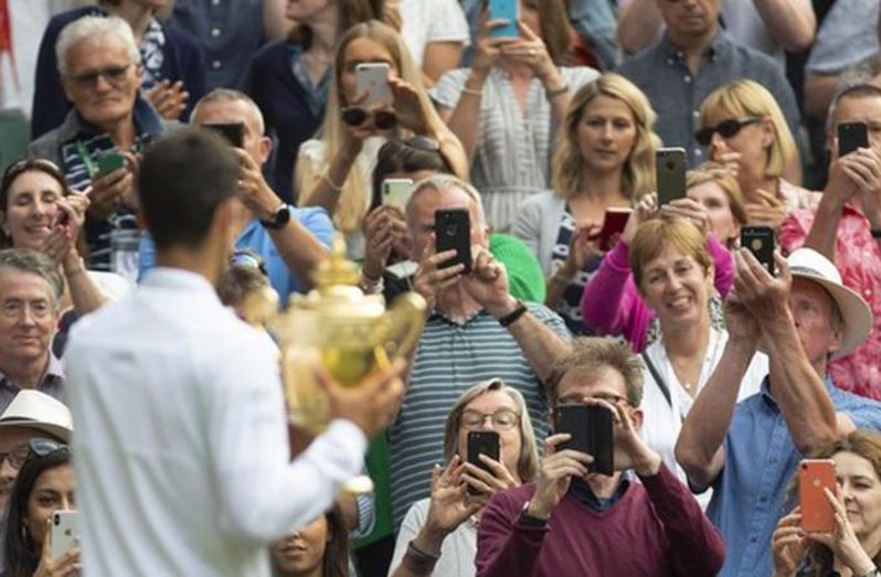 Serbia's Novak Djokovic celebrated with Centre Court fans after winning the men's singles title at Wimbledon in 2019