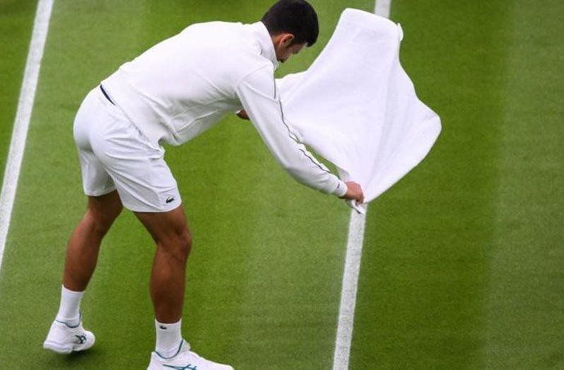 The players were off court for nearly 80 minutes with Novak Djokovic helping to dry the court,