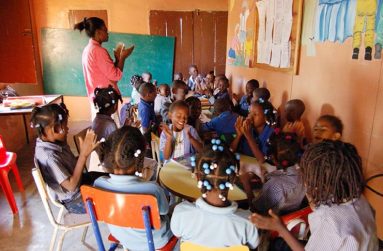 A nursery school teacher in front of the classroom, imparting knowledge
