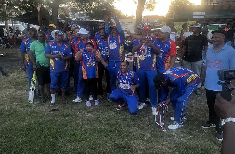 The victorious NYSCL Legends players pose with their winnings. NYSCL President Eric Ferrier is at extreme right.