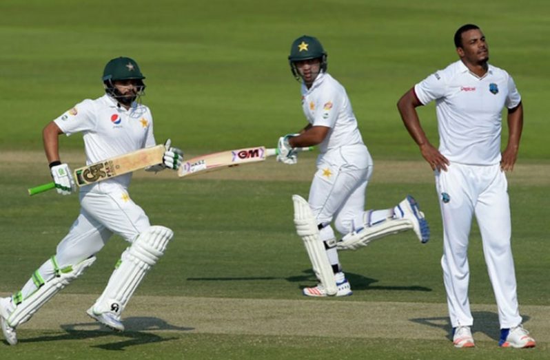 Pakistan batsmen Azhar Ali (L) and Sami Aslam (C) run between the wicket as West Indies' bowler Shannon Gabriel looks on during the third day of the second Test in Abu Dhabi on October 23, 2016 ©Aamir Qureshi (AFP)