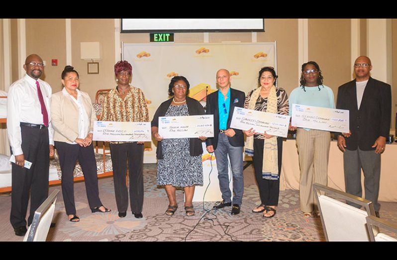 Tesouro Resources Chief Executive Officer (CEO) Dean Hassan (fourth right) and committee members Alex Graham (first left), Julia Johnson (second left) and Collen Williams (first right) with representatives of the four orphanages which benefitted from the donations. (Delano Williams photo)