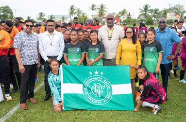 Prime Minister Mark Phillips (centre) and other government officials with one of the football teams contesting the Games.